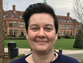 Staff member smiles in front of the HCA building